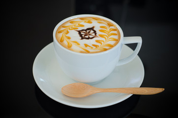 a cup of latte art on black background