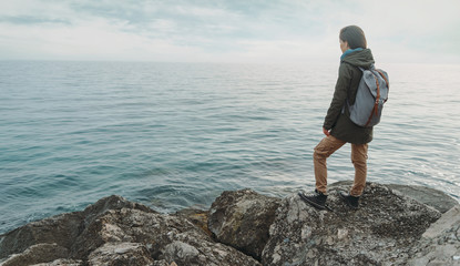 Woman standing on stone on coast