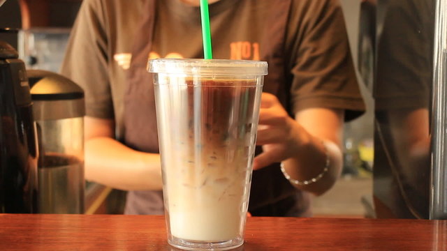 Barista Serving Doublewall Glass Of Iced Coffee Latte