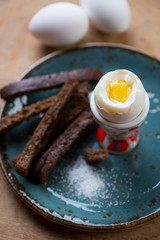 Close-up of soft boiled egg with toasts, selective focus