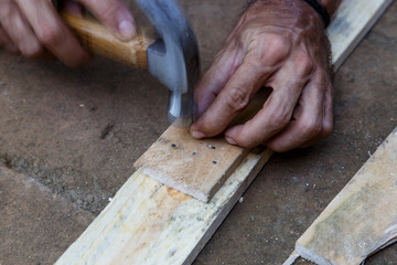 man hand working on wood with a hammer -serial-