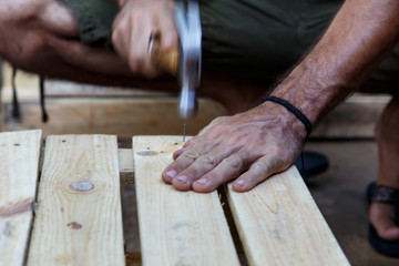 man hand working on wood with a hammer -serial-