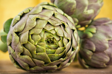 Obraz premium Group of fresh artichokes on wooden table