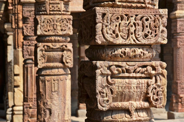 Columns with stone carving in courtyard of Quwwat-Ul-Islam mosqu