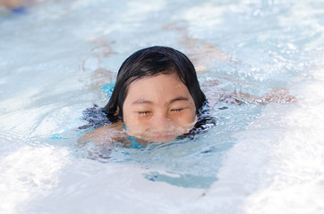 Fototapeta na wymiar Portrait of Asian girl swimming in swimming pool