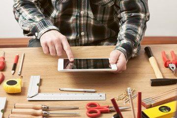 Craftsman working on a DIY project with his tablet