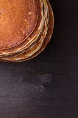 Stack of delicious pancakes on black