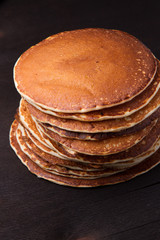 Stack of delicious pancakes on black