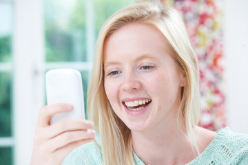 Smiling Young Woman Reading Text Message