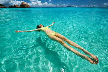 Woman in yellow bikini lying on water