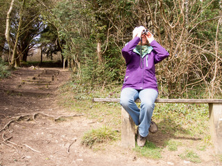Woman looking through a pair of Binoculars - 81391122