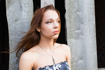Red-haired young girl near abandoned building