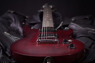Fototapeta na wymiar Electric guitar lying on black leather jackets