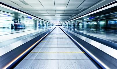 symmetric moving blue escalator inside contemporary airport © Cozyta