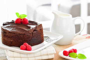 Fresh home made sticky chocolate fudge cake with raspberries