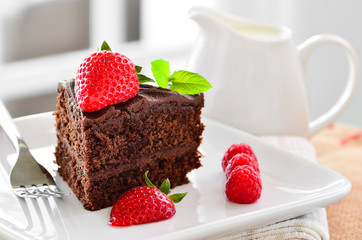 Fresh home made sticky chocolate fudge cake with strawberries