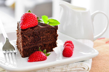 Fresh home made sticky chocolate fudge cake with strawberries