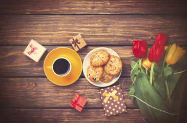 Cup of coffee with cookies and gifts