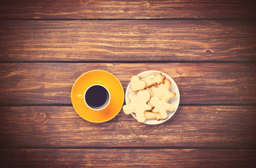 Cup of coffee and cookies on woden background.
