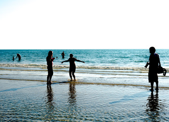 Beach in summer with people on the beach with silhouette people