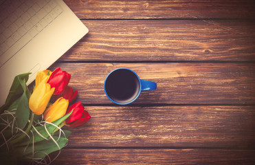 Cup of coffee and tulips with notebook
