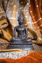 Buddha-Statue aus Bronze auf einem Seidentuch