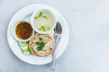 Rice roast chicken with spoon and fork on white plate.