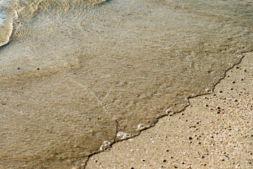 Sea water on beach sand closeup
