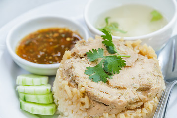 Rice roast chicken with spoon and fork on white plate.