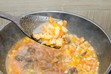 cooking pasta with chicken and meat gravy on stove