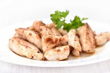 Toasted chicken meat sliced on white plate