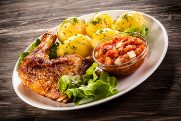 Barbecued chicken legs with boiled potatoes and vegetables