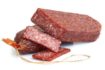 Premium salami, cut and sliced on white surface.