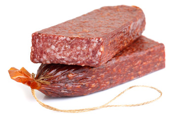 Premium salami, cut and sliced on white surface.