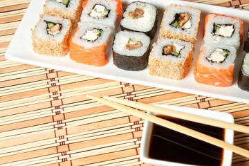 Sushi Assortment On White Dish over bamboo background.