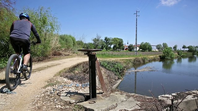 mountain bicycle riding in the countryside, irrigation channel