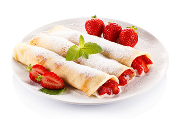 Crepes with strawberries and cream on white background
