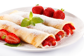 Crepes with strawberries and cream on white background