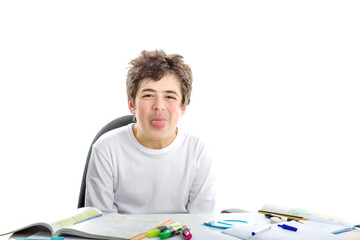 Caucasian smooth-skinned boy makes tongue grimacing on homework
