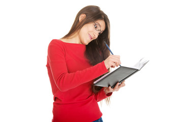 Female student writing in notebook.