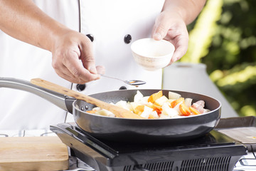 Chef putting seasoning sauce to the pan for cooking Japanese por