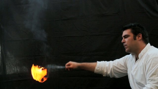 fire-eater with flame over dark background