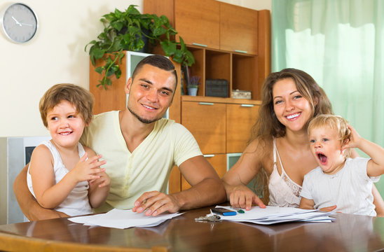 Parents and little daughters with documents