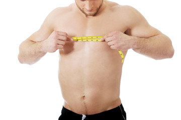 Fototapeta na wymiar Muscular man measuring his chest.