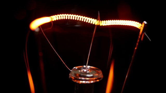 Real light bulb flickering. Incandescence thread, close up. 4K.
