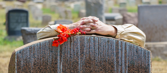 Lone Figure of Person Grieving at Cemetery