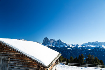 High-altitude mountain hut in front of a panorama of snow-capped