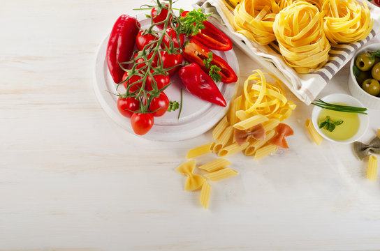 Italian food ingredients on a whiete wooden background.