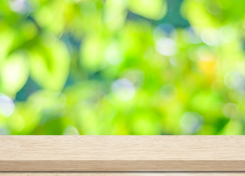 Empty wood table over blurred trees with bokeh background