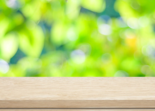 Empty wood table over blurred trees with bokeh background